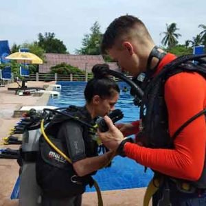 PADI Reactivate Scuba Refresher Program divers buddy check by the side of the swimming pool
