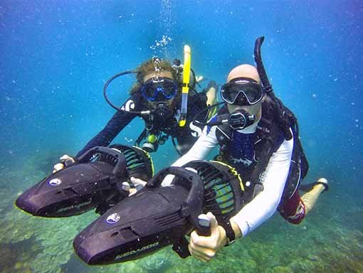 PADI Diver Propulsion Vehicle Specialty divers underwater with dpv