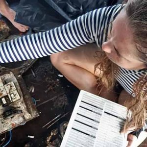 Padi Dive Against Debris Specialty girl with slate sorting trash on boat