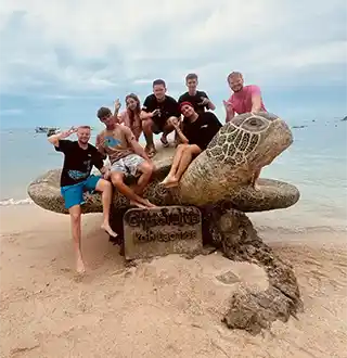Instructor and Divemaster Course trainee with Open Water students celebrating