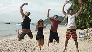crystaldive.com-scuba-diver-course-happy-divers-jump-on-beach