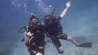 crystaldive.com-adventure-diver-happy-divers-underwater-hug Crystal Dive advanced adventure divers hugging underwater