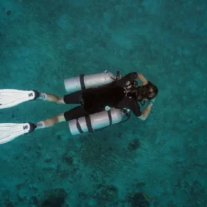 A diver doing the Sidemount Diving course seen from above swimming around the clear water of Koh Tao Thailand