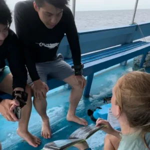 Divemaster Instructor (DMI) candidate briefing Open Water Course students on the Crystal Dive boat on Koh Tao