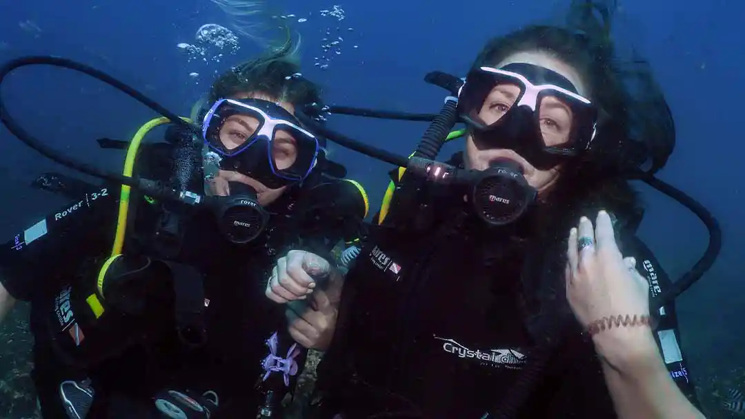 crystaldive.com-scuba-review Crystal Dive happy divers underwater smiling at the camera