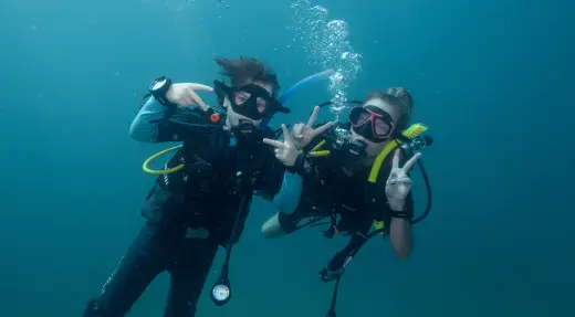 Kids diving with mom buddy showing peace sign