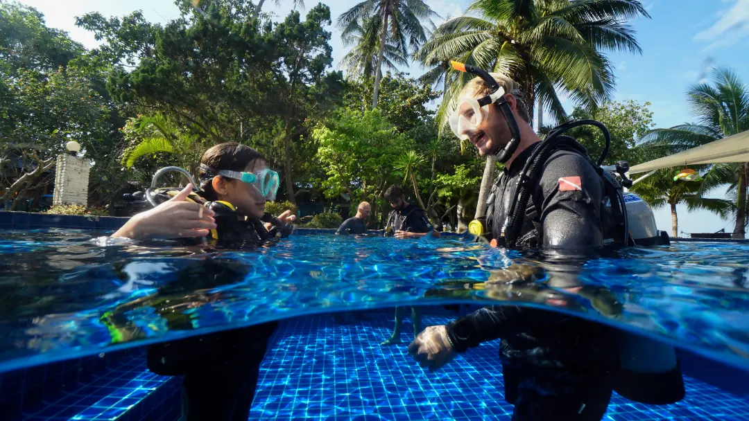 Junior Open Water Course diver with instructor standing in the pool