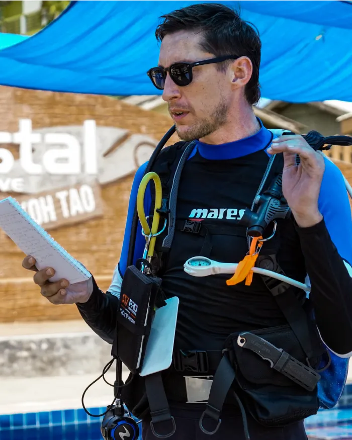 assistant instructor trainer course candidate reading briefing assistant instructor trainer course candidate briefing next to the pool