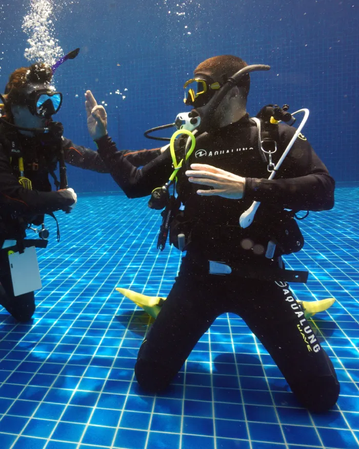 assistant instructor trainer course pool demonstration ok sign assistant instructor trainer course candidate preparing to demonstrate in the Crystal Dive pool