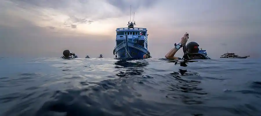 chronicles-best-time-to-dive-night-divers-descend Four happy student divers and their instructor underwater with Crystal Dive during the best time to dive on koh tao