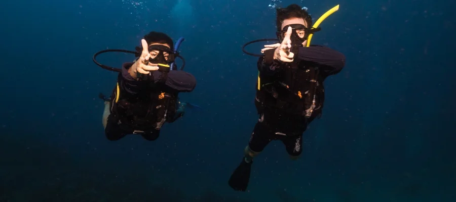 chronicles learn to scuba dive on koh tao divers fingerguns Four happy student divers and their instructor underwater with Crystal Dive during the best time to dive on koh tao