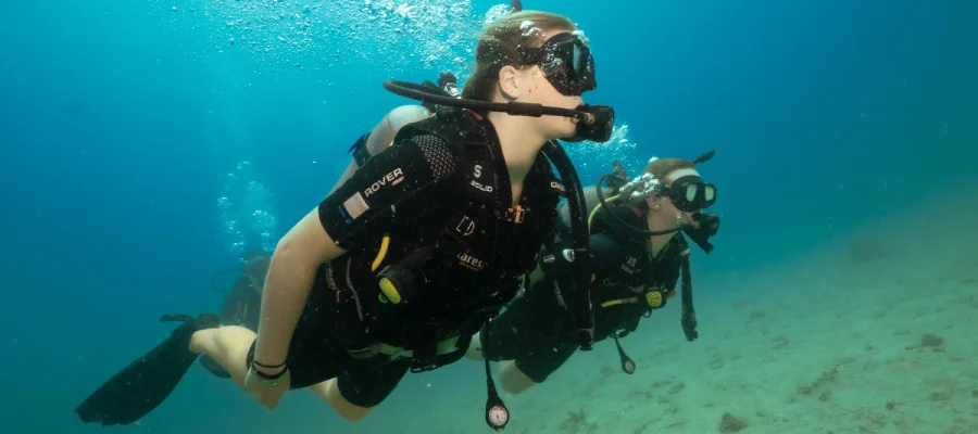 chronicles learn to scuba dive on koh tao two divers swimming Two divers learning to dive swimming side by side on Koh Tao