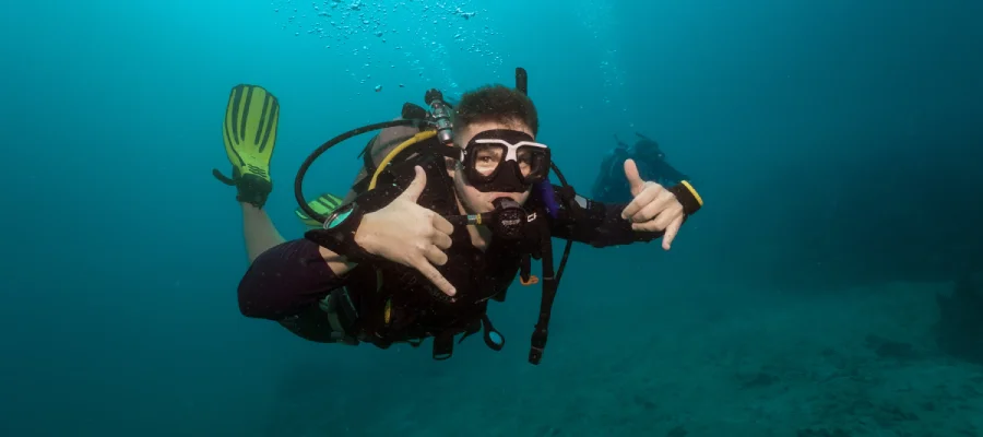 Diver showing double shaka sign while diving around Koh Tao