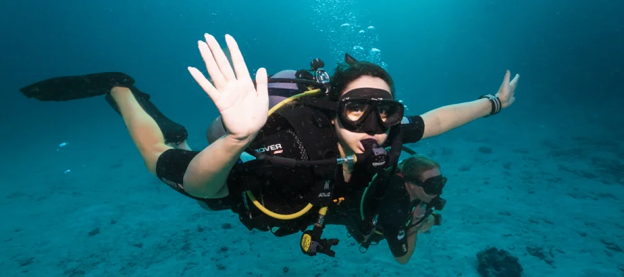 Diver waving and smiling during a dive around Koh Tao