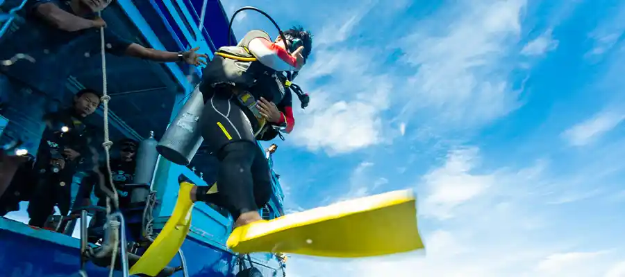 A scuba diver giant stride entry to open water