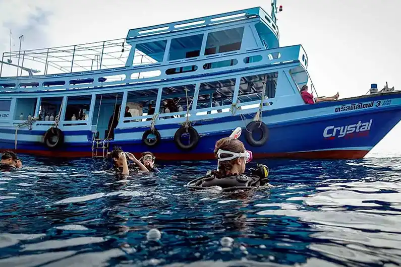 Crystal dive boat with fun divers and guide in the water around Koh Tao