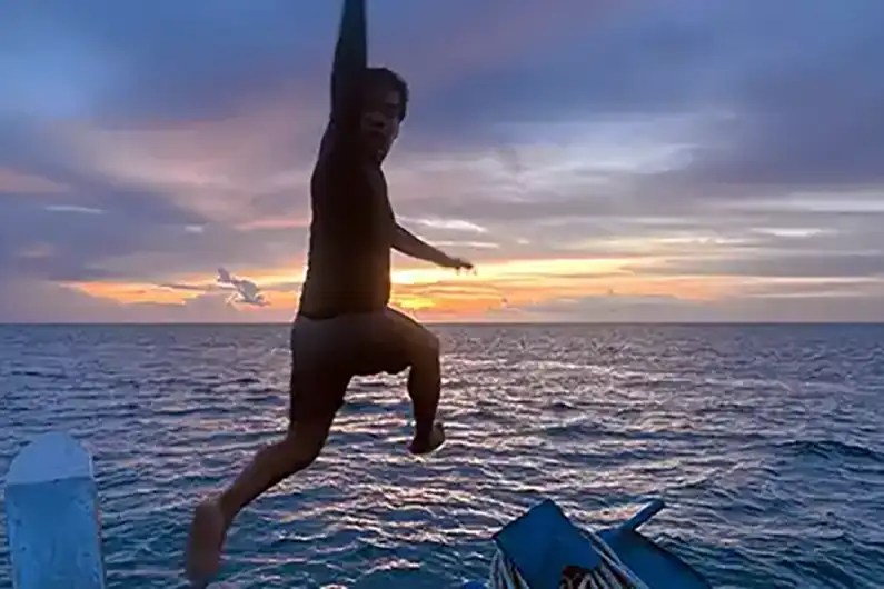 Crystal Dive Instructor jumping in the water on a Night Dive around Koh Tao