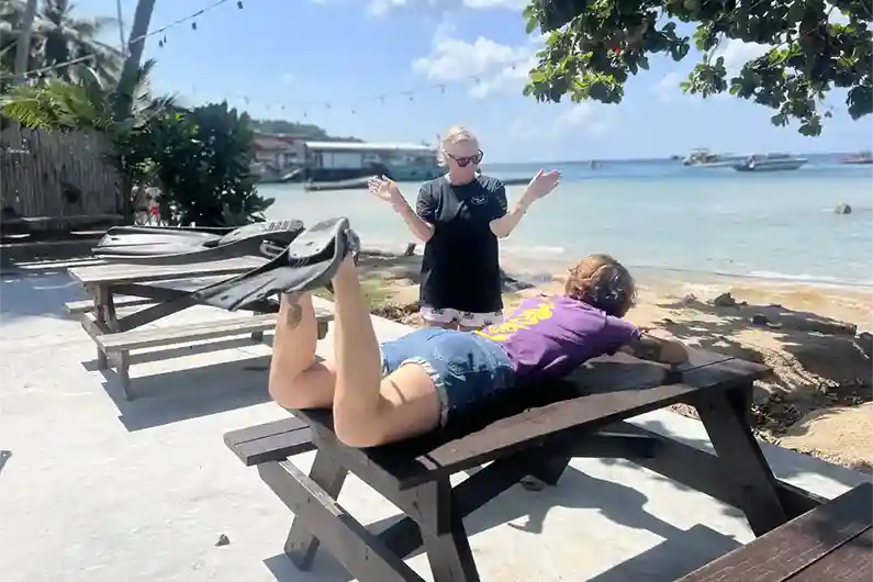 Instructor showing Perfect Buoyancy Skills course student fin techniques on land