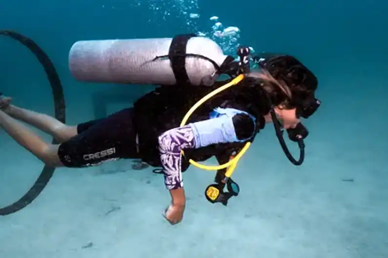 Perfect buoyancy specialty course student swimming through hoop at Buoyancy World dive site Koh Tao