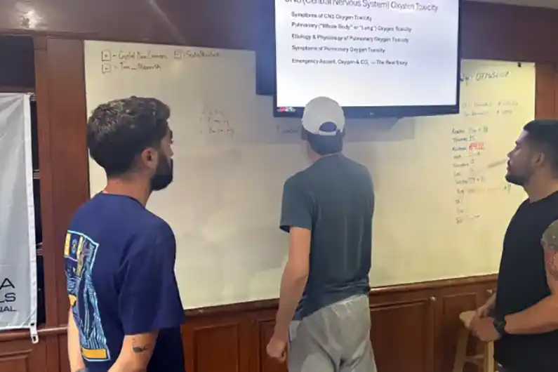 science of diving course classroom three people writing on the whiteboard at Crystal Dive