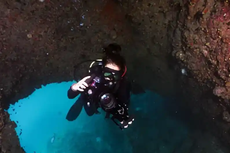underwater photography specialty course diver going through chimney at sail rock dive site