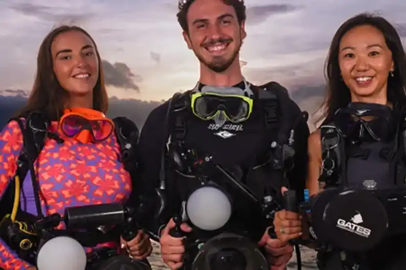 underwater photography specialty course participants standing with cameras on the beach