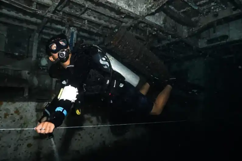 Instructor holding line during SSI Wreck Specialty course inside Suphairin 313 on Koh Tao Thailand